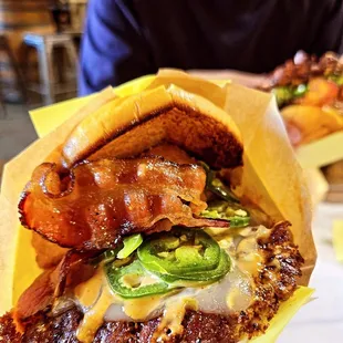 Hellapeño burger: 2 patties, pepperjack cheese, grilled onions, pork bacon, jalapeños, onion rings, smack sauce, mikes hot honey.