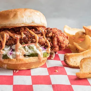 a chicken sandwich with coleslaw and fries