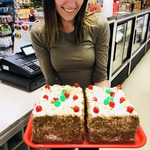 a woman holding two cakes