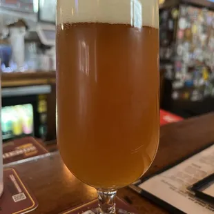 a glass of beer on a bar