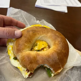 Breakfast sandwich on bagel with bacon, egg, cheese, and jalapeño