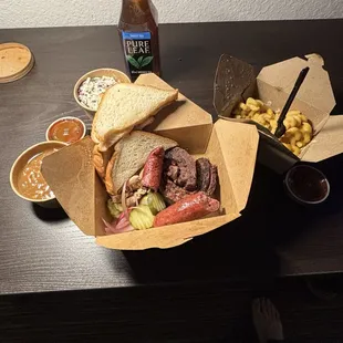 3 protein meal. Sliced brisket, sausage and pulled chicken. Baked beans, Smoked Mac n Cheese, coleslaw. Bread and pickled veggies.