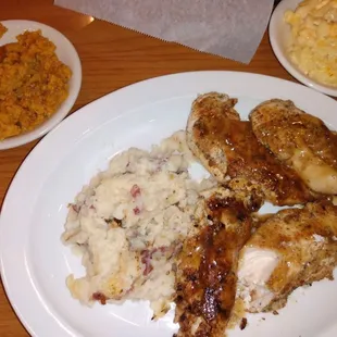 a plate of chicken, mashed potatoes, and macaroni and cheese
