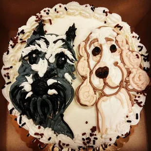 two dogs on top of a cake