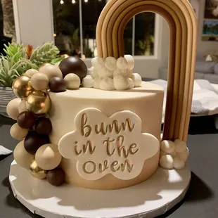 2 tier cake, muted-pastels, rainbows, "Bunn (last name) in the oven"