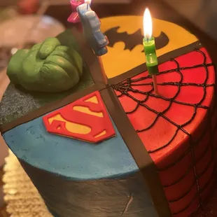 a superman cake with candles