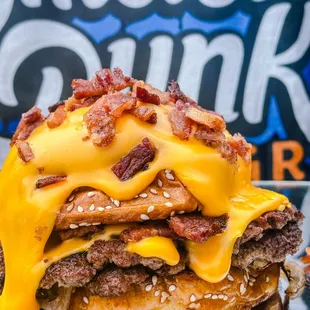 Lay up - two smashed patties smothered with cheddar sauce, chopped bacon, served on buttered sesame bun.