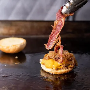 a bacon and cheese sandwich being made