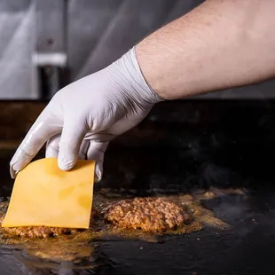 a hand in a white glove holding a piece of cheese