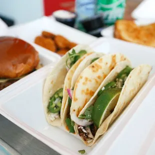 a tray of tacos and a burger