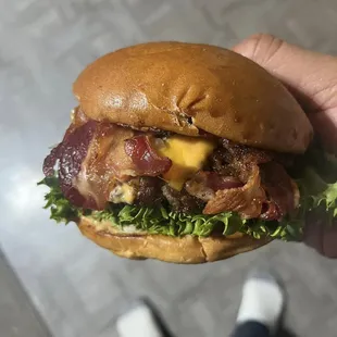 a hand holding a burger
