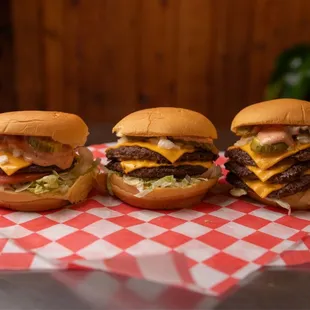 three cheeseburgers on a table