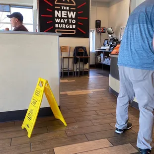 a yellow caution sign in a restaurant
