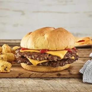 cheeseburger and tater tots on a cutting board