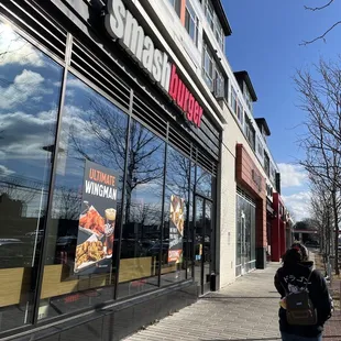 a woman walking past a fast food restaurant