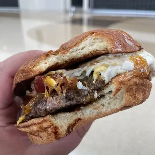 a hand holding a half eaten sandwich