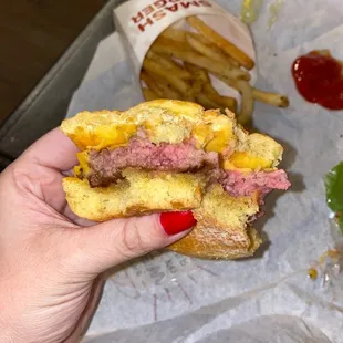 a hand holding a half eaten sandwich