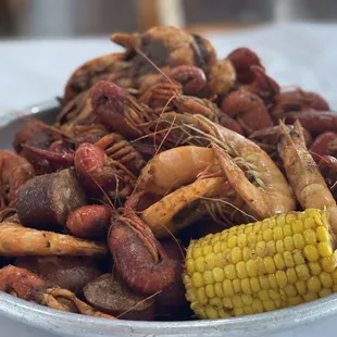 a bowl of shrimp, corn, and sausage