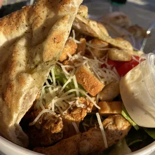 a bowl of food with bread and salad
