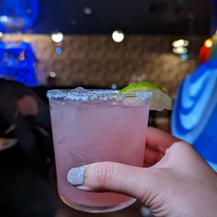 a hand holding a margarita