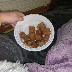 a person holding a plate of chicken nuggies