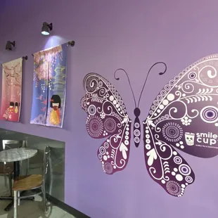 a butterfly on a purple wall