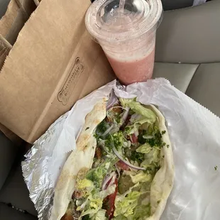 Falafel sandwich and strawberry banana smoothie on the seat of my car.