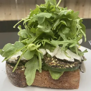 a sandwich with greens on top