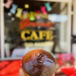 a hand holding a chocolate donut