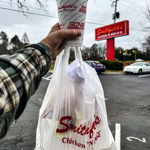 ws a hand holding a cup of chicken