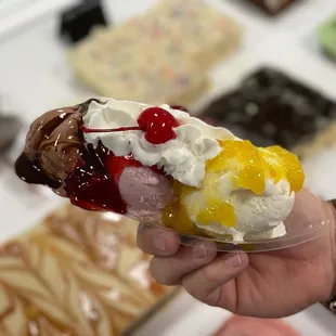 a hand holding a sundae