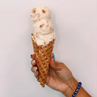 a hand holding an ice cream cone