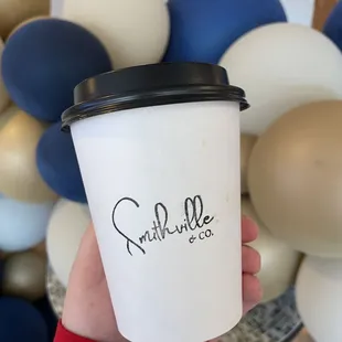 a hand holding a cup of coffee