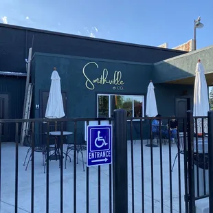 the outside of a restaurant with tables and umbrellas