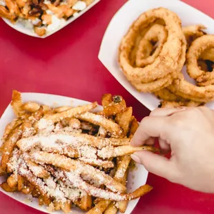 a hand grabbing a piece of fries