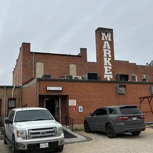 two trucks parked in front of a brick building