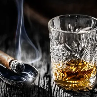 a glass of whiskey and a cigar