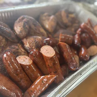 a tray of sausages and potatoes