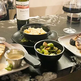 Fillet with blue cheese, roasted potato, brussels sprouts, mac n cheese, and pork chop with chimichurri sauce.