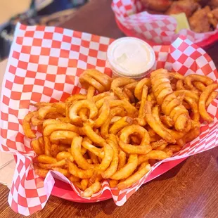 a basket of onion rings and a basket of fries