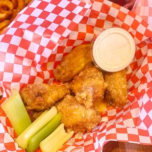 a basket of chicken nuggies and celery sticks