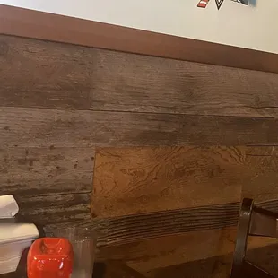 A roach crawling right below the second wood panel. Almost same color as the wood