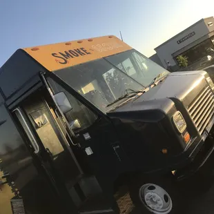 a black food truck parked in a parking lot