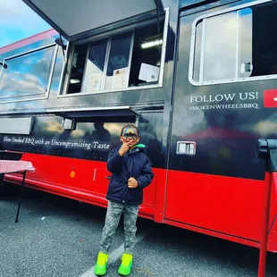 ows a man standing in front of a food truck