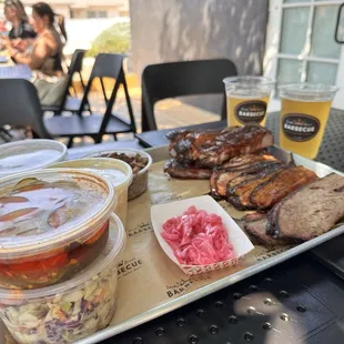 Brisket, pork slices, ribs, pickle onions, spicy cucumber salad, slaw, dirty rice, Mac &amp; cheese