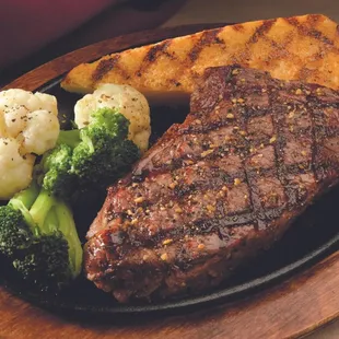 12 oz Kansas City strip steak cooked over hickory logs, served with your choice of one side and a  house salad with mixed bab...