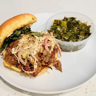 Brisket sandwich with collard greens. Sandwich is topped with their amazing slaw and kale... so yummy!