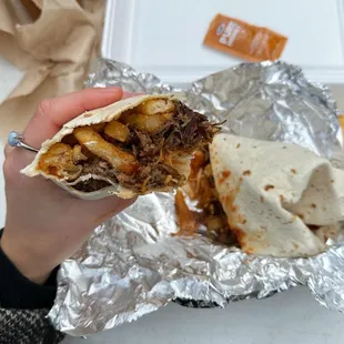 a hand holding a burrito