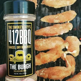 a hand holding a bottle of bbq