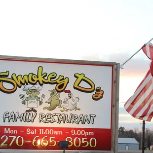 Smokey D's sign at sunset with the American Flag attached to the sign.
